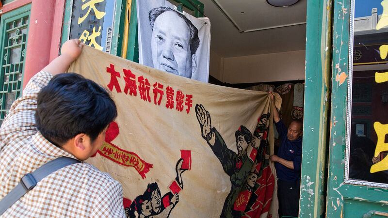 当局利用毛左肯定文革 但压制其行动。图为民众展开了 1969 年的横幅,描绘了中国前领导人毛泽东“视察文革大军”和“大海航行靠舵手”的标语。(美联社图片)
